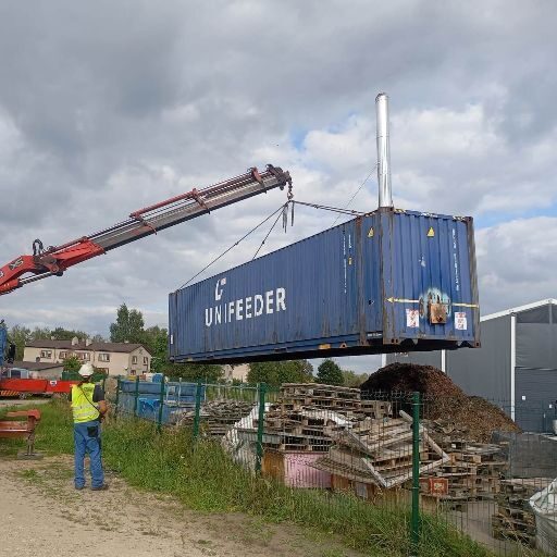 Manipulators paceļ jūras konteineru. Manipulatora pakalpojumi piemēroti konteineru un citu liela izmēra kravu pārvietošanai